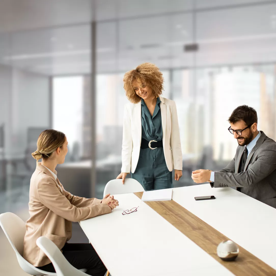 Drei Personen an einem Tisch, zwei sind am sitzen