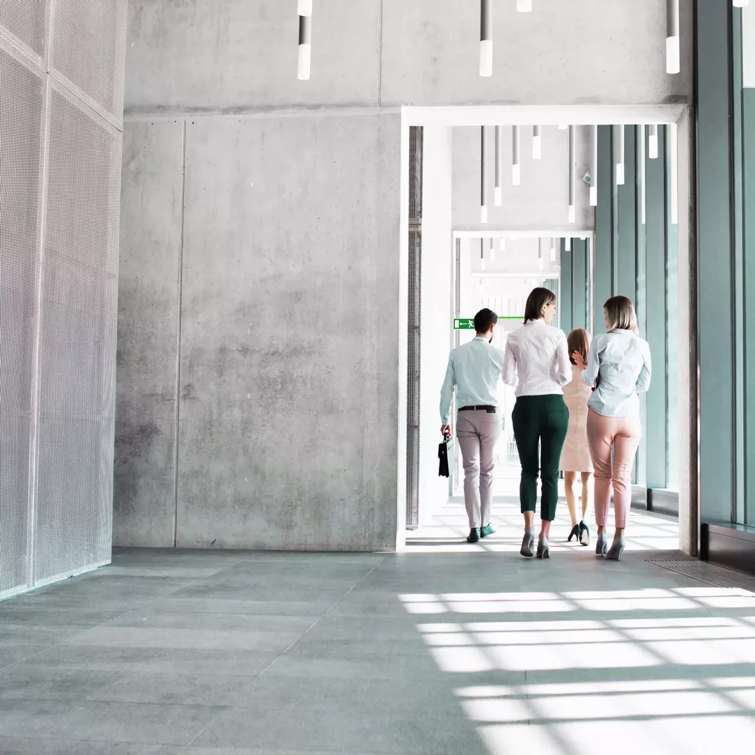 Personen in einem Gebäude gehen zusammen durch einen Flur